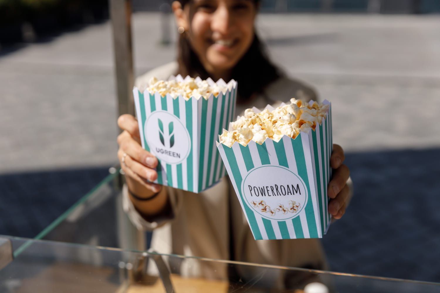 Mitarbeiter präsentiert gebrandete Popcorntüten am Popcornwagen in Berlin.