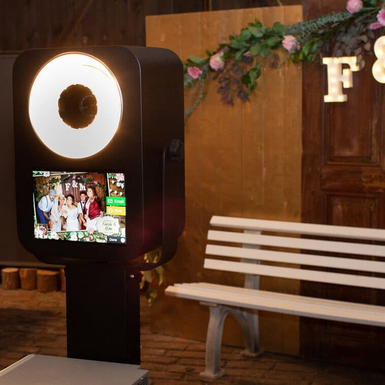 Fotobox auf einer Hochzeit mit stilvollem Hintergrund und romantischer Dekoration.