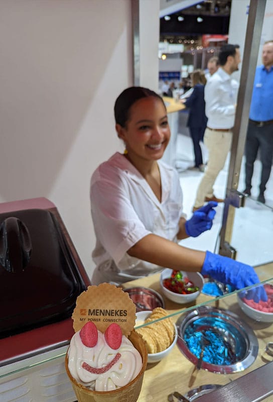 Servicemitarbeiterin bei der Ausgabe von Frozen Yogurt auf einer Messe.