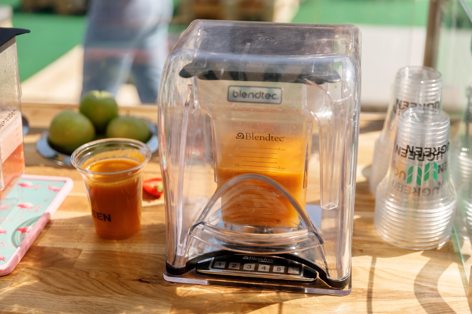 Frisch zubereiteter Smoothie in einem gebrandeten Becher bei einer Promotionveranstaltung.
