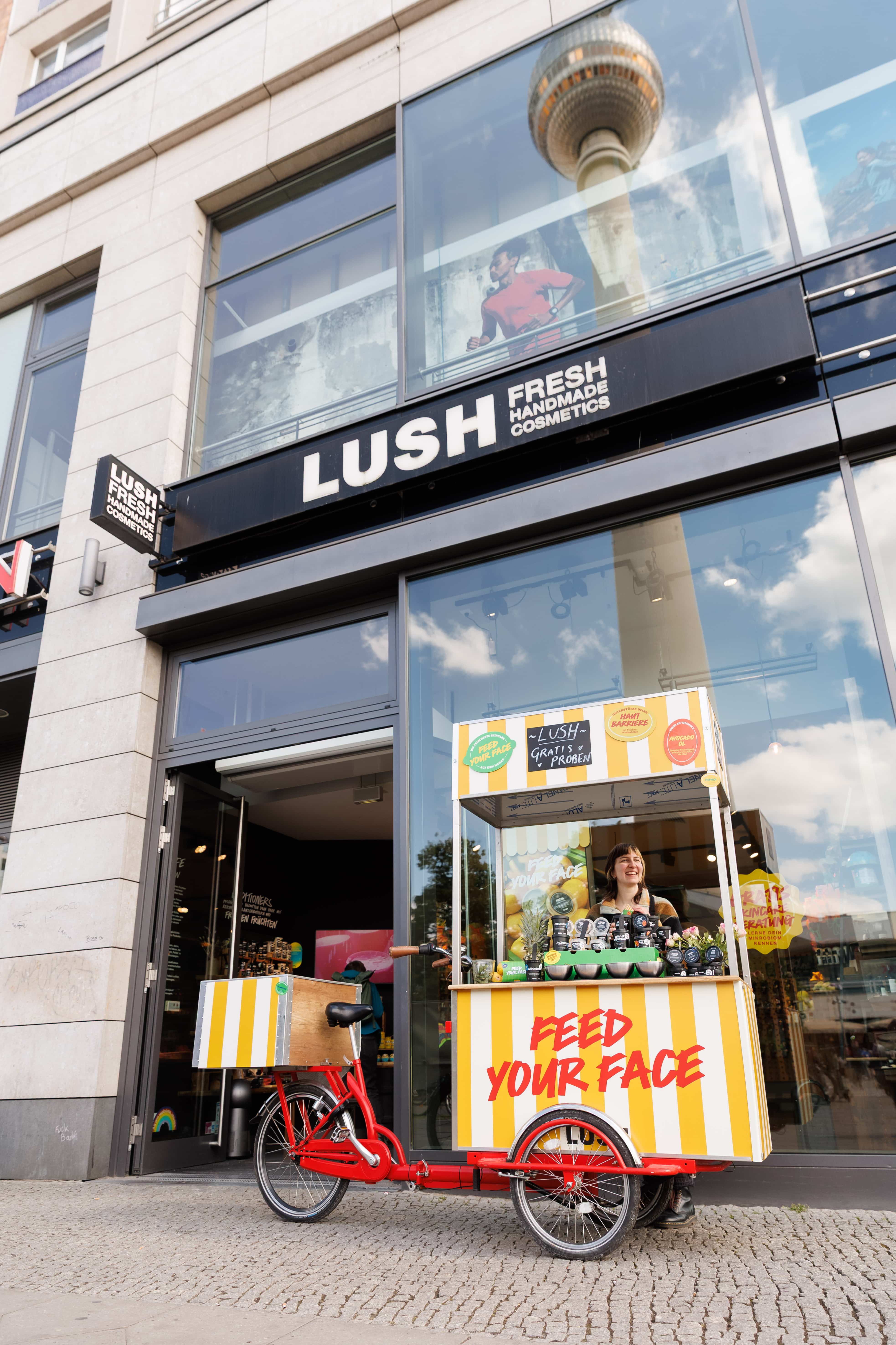 Mobile Kosmetikaktion mit Fahrradstand und Verkäuferin vor einem Innenstadtgeschäft