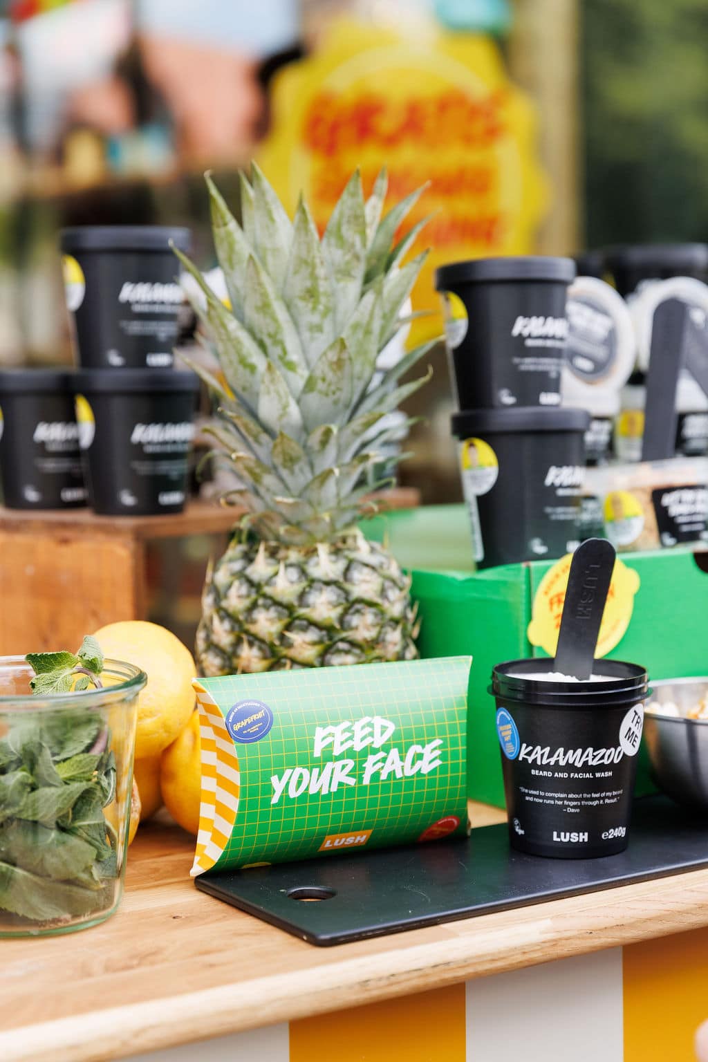 Kosmetikprodukt mit frischer Ananas, Zitronen und Kräutern auf einem Holztresen