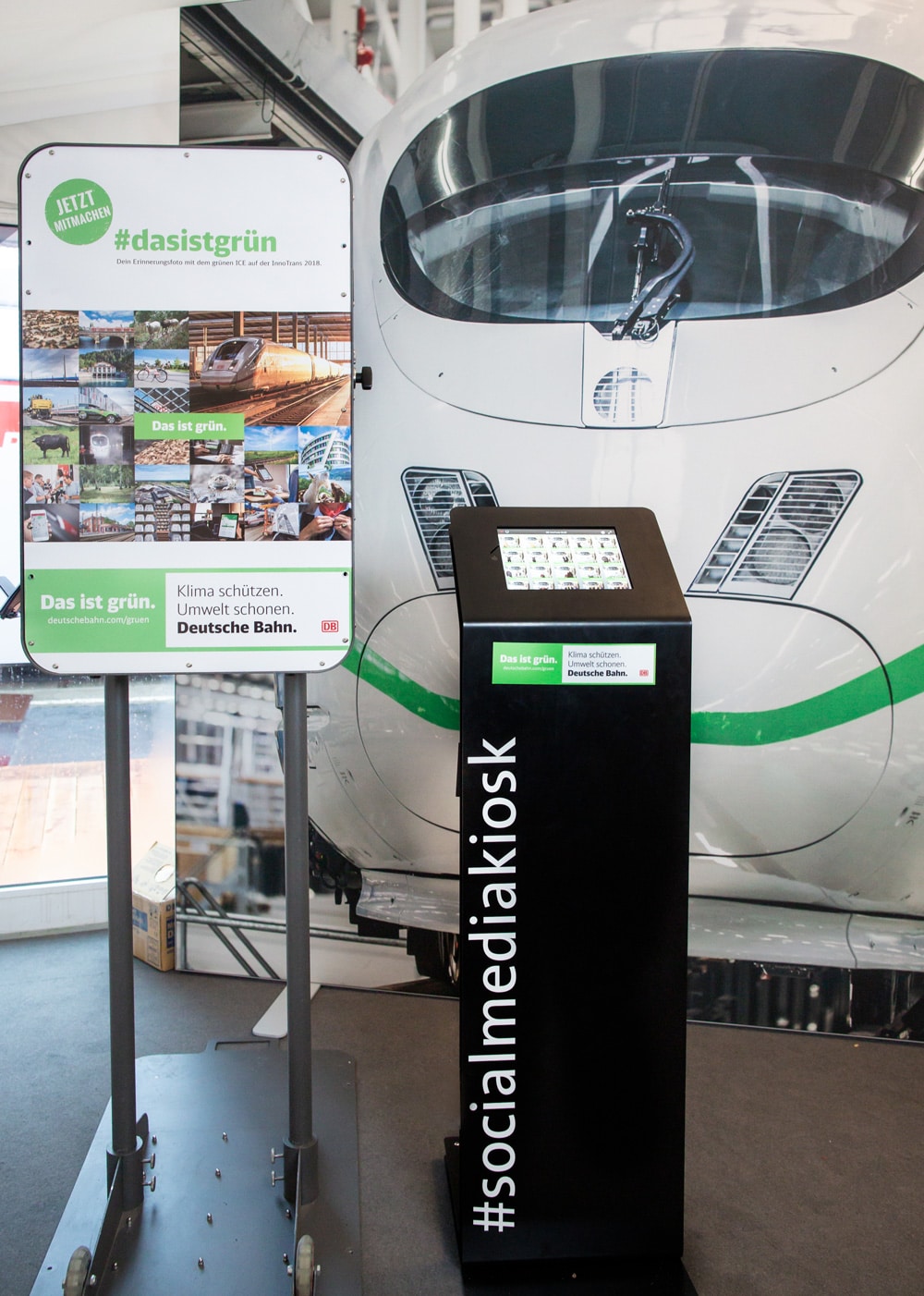 Social Media Kiosk der Deutschen Bahn vor einem ICE auf der InnoTrans im Rahmen der Kampagne #dasistgrün.